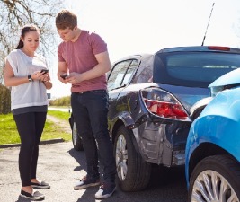 Woman and man exchange information after car accident