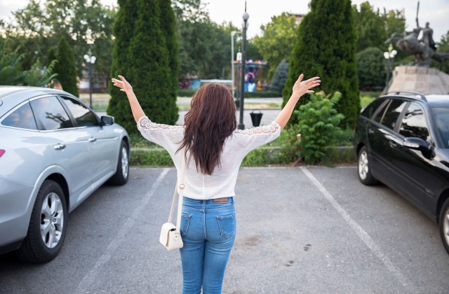 Woman standing in front of empty parking spot, car stolen