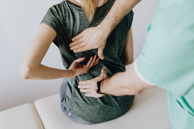 Woman being treated by a doctor for back pain