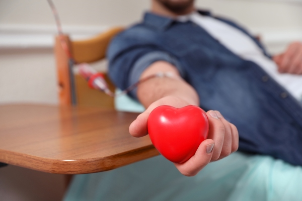 Man donating blood squeezing heart stress reliever