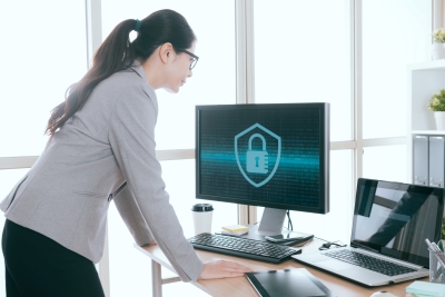 Businesswoman looking at computer - Cyber Liability Insurance Texas