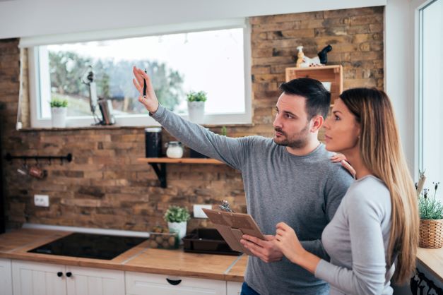 Couple reviewing remodel options in kitchen - Home Remodel Insurance TX