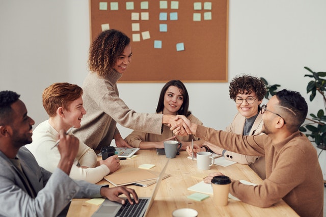 Woman shaking hands with a man after completing a business deal