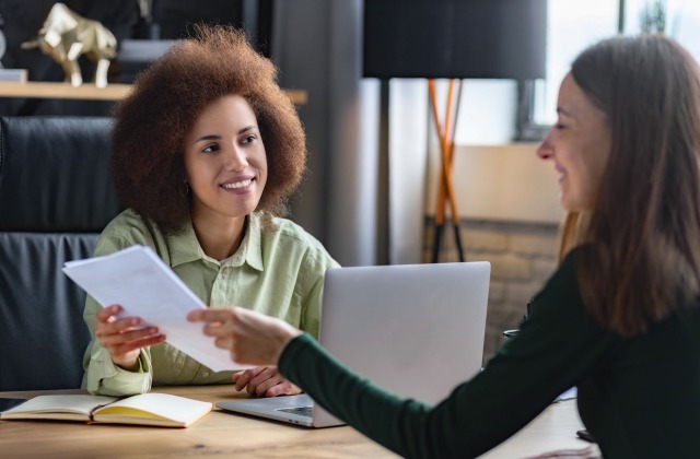 Women insurance agent discussing third-party employment practices liability insurance with female client.