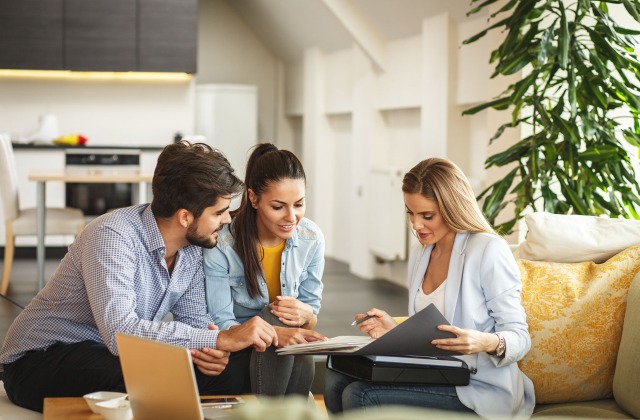 Young couple meeting with insurance professional to understand how insurance can protect their family.