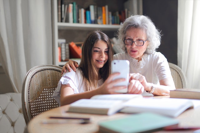 Grandmother looking at phone with granddaughter 
