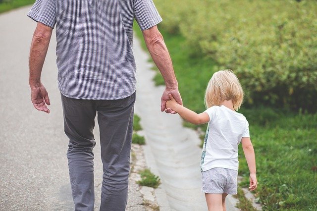 Dad walking with daughter holding hands